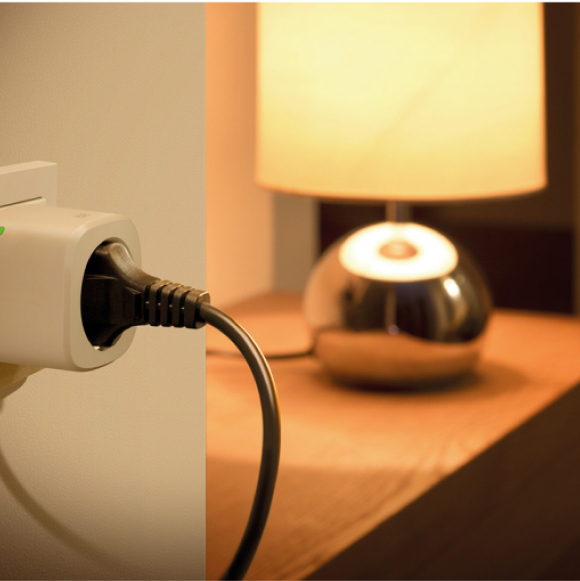 Smarte Steckdose Eve Energy in einer Steckdose mit angeschlossener smarten Lampe