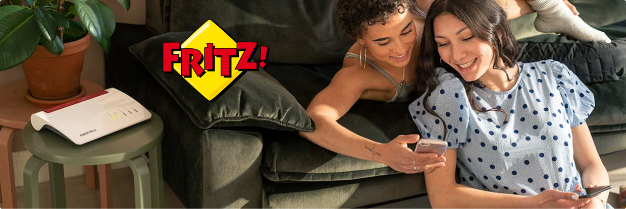 Paar auf der Couch mit Smartphone neben der FRITZ!Box