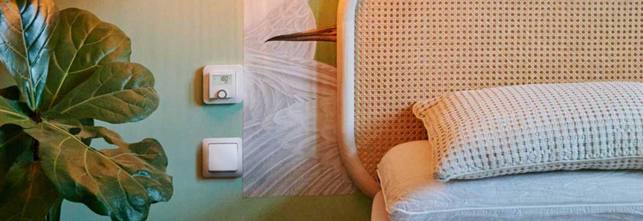 Das Bosch Raumthermostat an die Wand montiert neben dem Bett im Schlafzimmer.