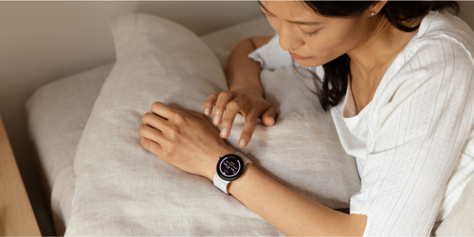 Frau mit Google Pixel Watch 2 am Handgelenk überprüft Schlafdaten