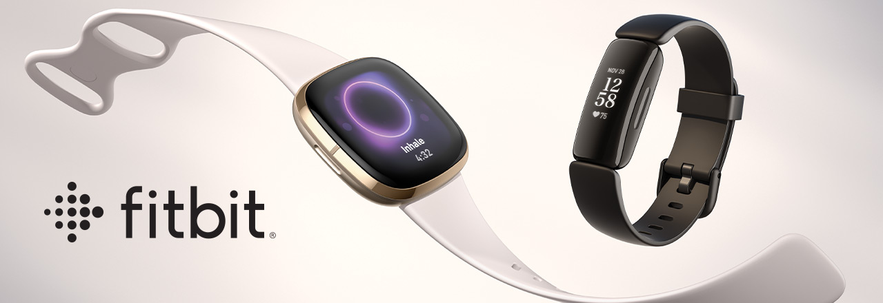 Fitbit Armband und Firbit Smartwatch neben Fitbit Logo